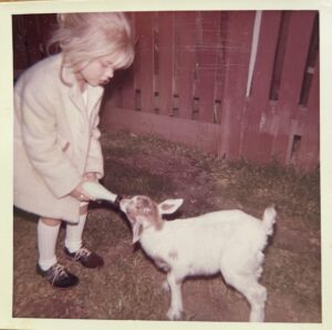 Elizabeth Crook petting her goat in her childhood